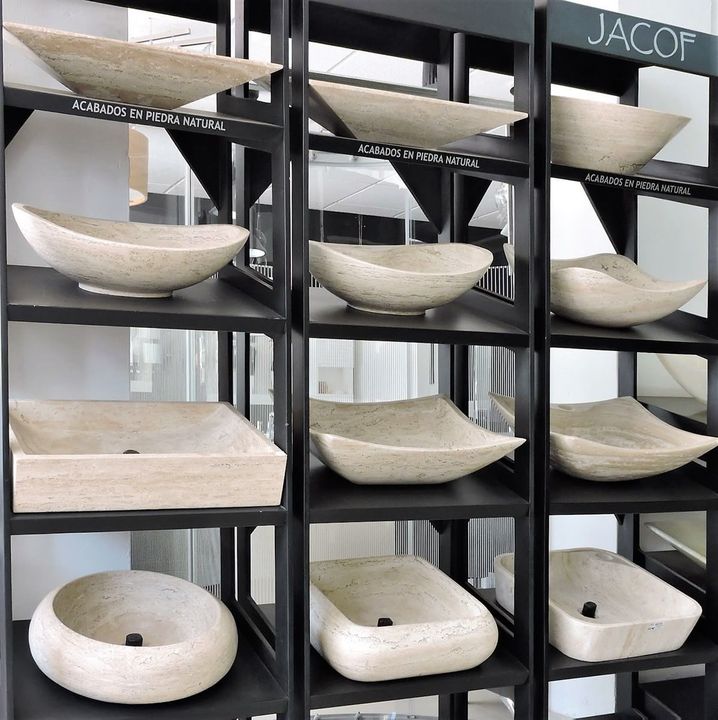 Carved natural stone vessel basins on display shelves