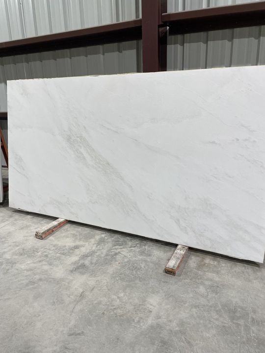 Polished white slab with light grey veins in a warehouse