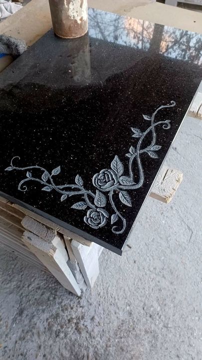 Rose vine motif engraved into a black granite panel